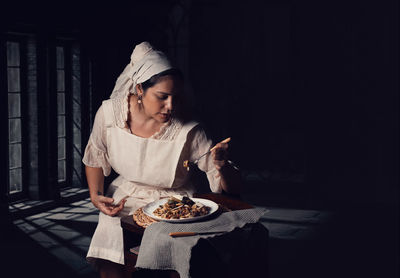 Portrait of young woman preparing food on table