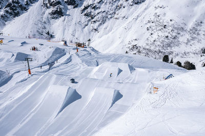 High angle view of drag lift on snow covered landscape in alps on sunny day