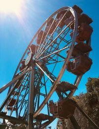 Low angle view of ferris wheel against blue sky