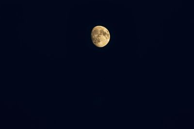 Low angle view of full moon against clear sky at night