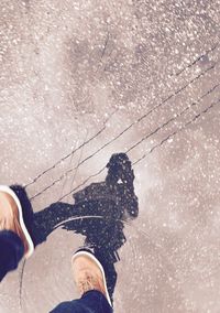 Low section of man stepping in puddle