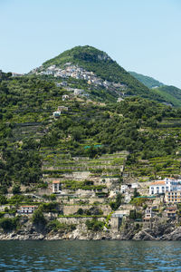 Scenic view of sea by buildings against clear sky