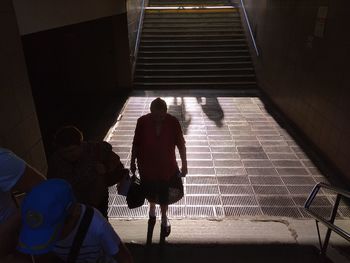 Rear view of people walking on staircase