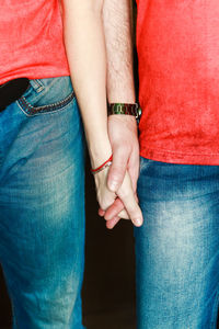 Midsection of couple holding hands