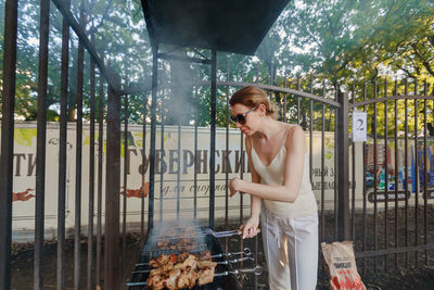 Woman standing on barbecue grill