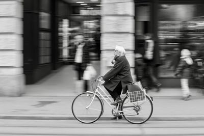 Woman riding bicycle on street in city