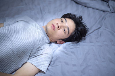 High angle view of man lying on bed