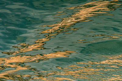 High angle view of reflections on rippled water in venetian canal.