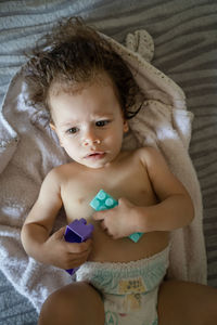 Close-up of cute girl playing with toy on bed at home