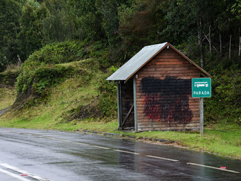 Road sign by trees in forest