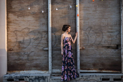 Full length of woman standing against window