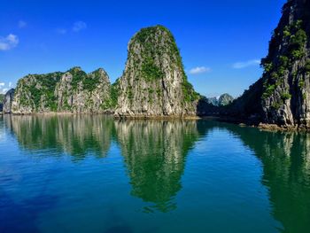 Scenic view of lake and rock formations against blue sky