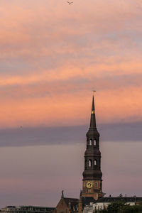 Tower of building against sky during sunset