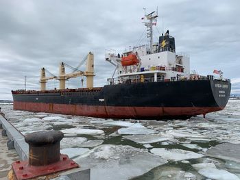 Ship moored on sea against sky during winter