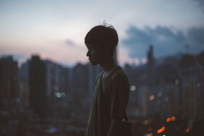 Man in city against sky