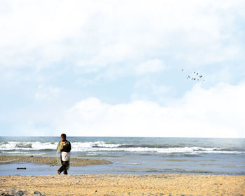 Man standing on beach against sky