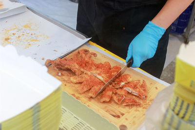 Close-up of hand holding ice cream cone on table