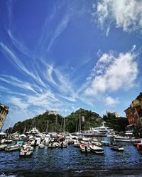 Boats moored in harbor against buildings in city