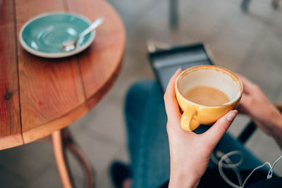 Close-up of hand holding coffee cup