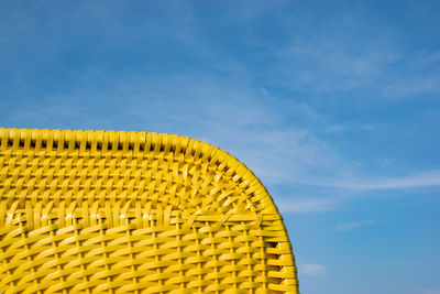 Low angle view of yellow metallic structure on beach against sky
