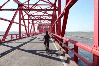 Man on bridge over sea against clear sky