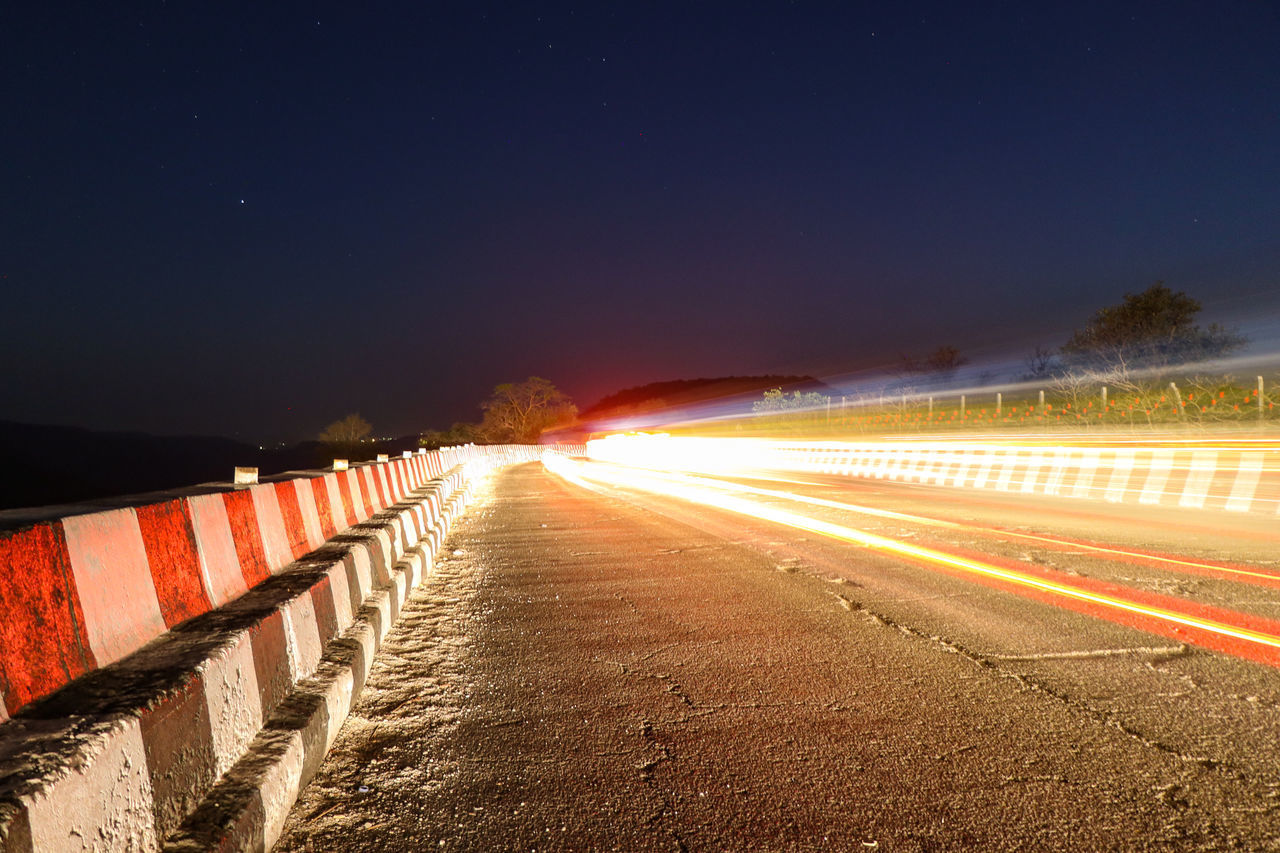 LIGHT TRAILS ON STREET AT NIGHT