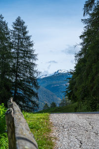 Scenic view of road by mountains against sky