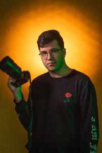 Portrait of man standing against yellow background