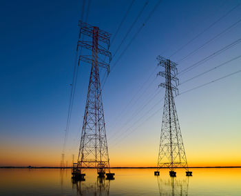 High voltage transmission lines crossing wheeler lake at dusk near athens al. 