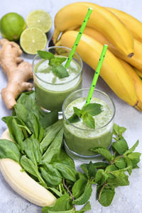 Fresh organic detox green drink smoothie with spinach, banana, lime and ginger with refreshing mint