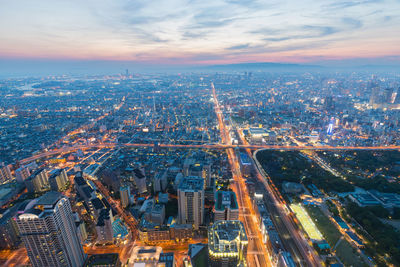 High angle view of illuminated city buildings against sky