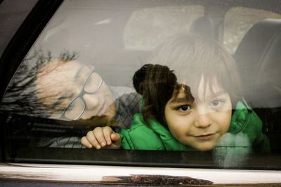 Portrait of boy and girl on back seat of car
