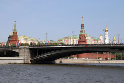 Arch bridge over river against buildings in city