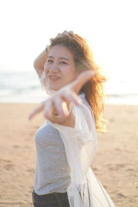 Beautiful young woman standing on beach