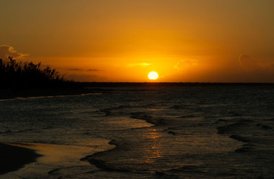 Scenic view of sea against orange sky