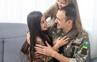 Daughters embracing father at home