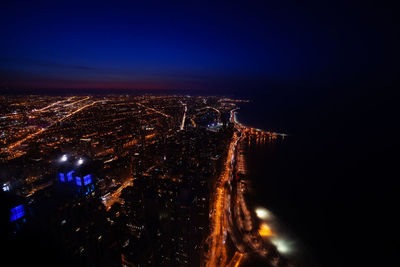 High angle view of illuminated buildings against sky at night