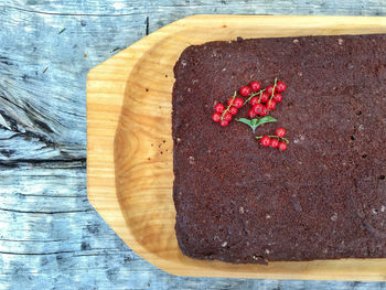 High angle view of red berries on cake in tray at table