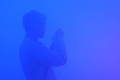 Man standing against blue sky