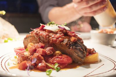 Close-up of hand holding food served in plate