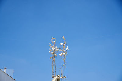 Low angle view of telephone pole against clear blue sky