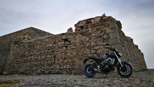 Low angle view of stone on rock against sky