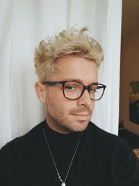 Portrait of young man wearing eyeglasses at home