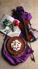 Directly above shot of dessert by violin and musical note on table