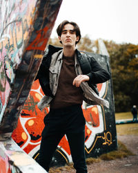 Portrait of young man standing on wall