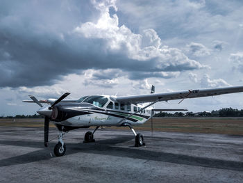 Side view of airplane at airport runway against sky