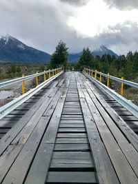 Surface level of footbridge against sky