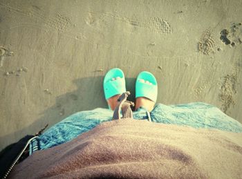 Low section of woman standing on sand