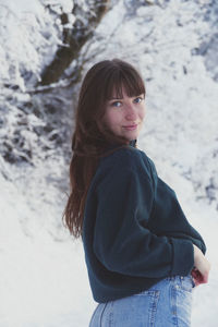 Portrait of woman standing on snow covered land