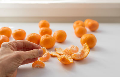 Close-up of hand holding orange fruits